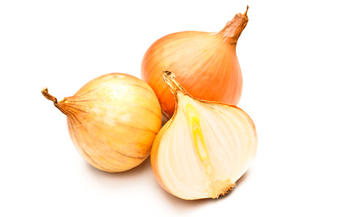 Three yellow onions with one sliced in half